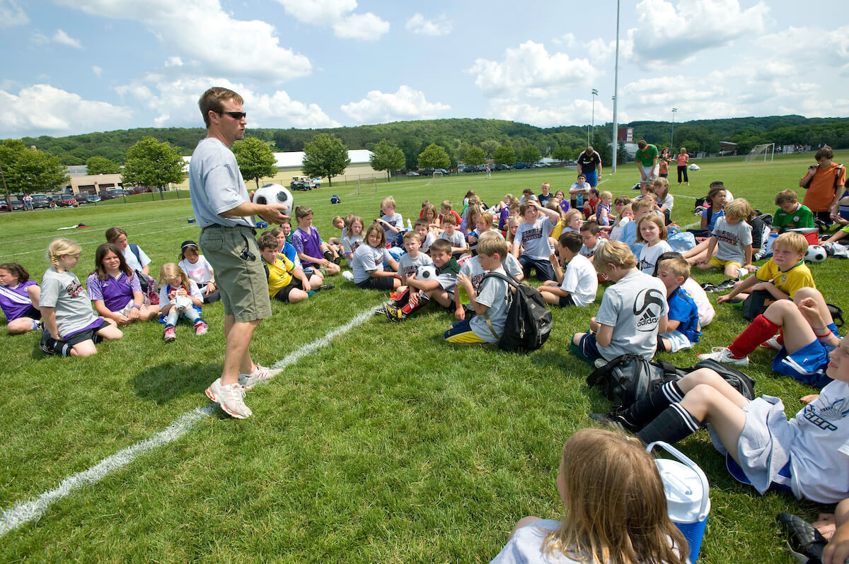 Colgate’s head soccer coach speaks to participants of a youth soccer camp on the university’s campus.