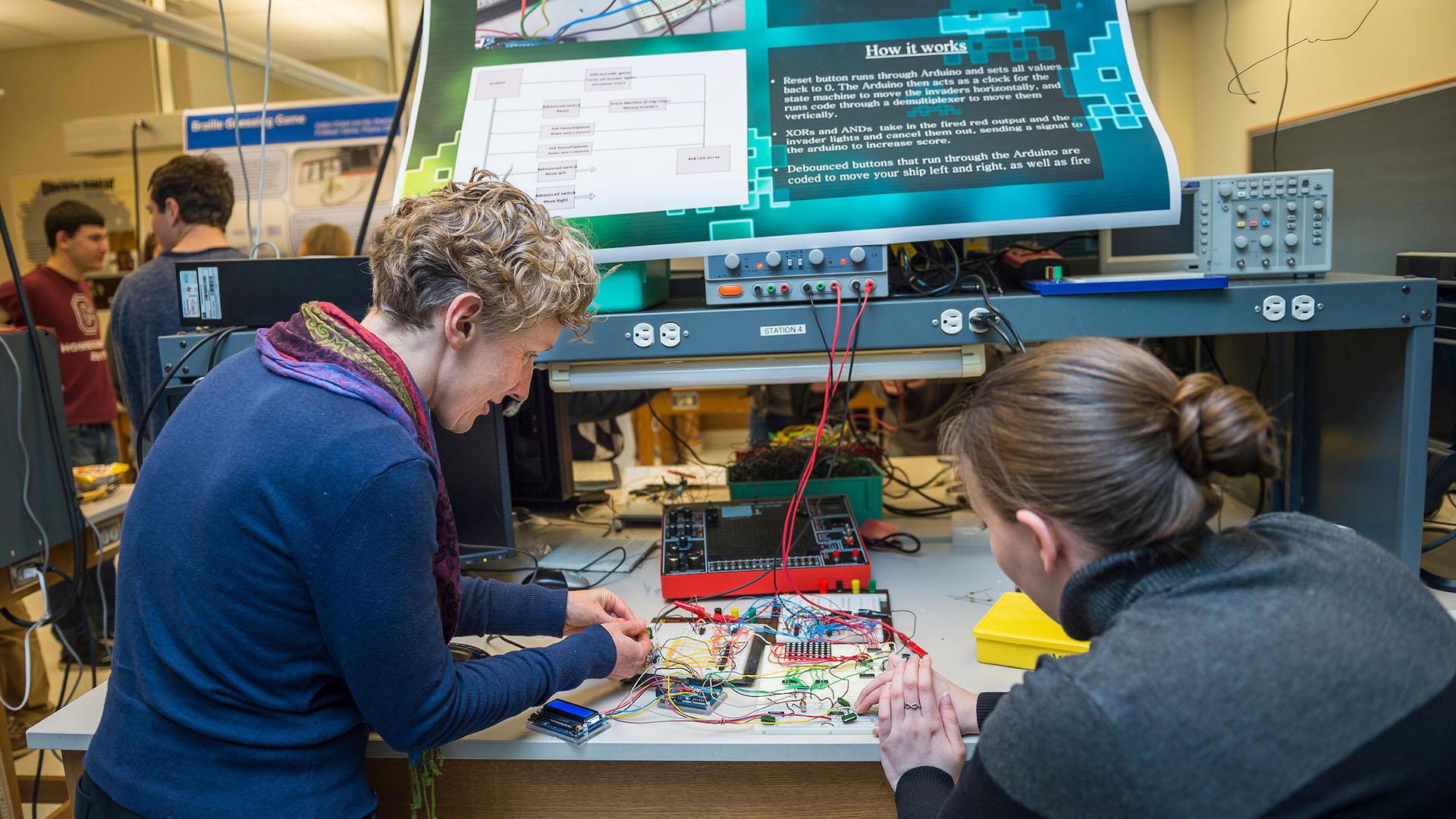 Associate Professor of Physics and Astronomy Beth Parks investigates an electronic game with a physics student.