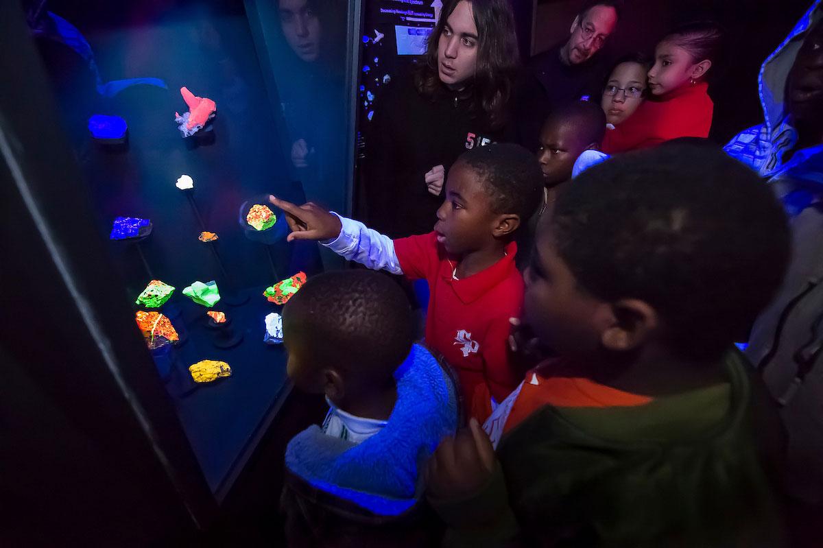 Fluorescent minerals light up visiting students faces at the Ho Tung Visualization Lab.