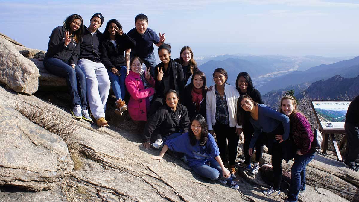 John Palmer and the students in his study group take a group photo on a rock face
