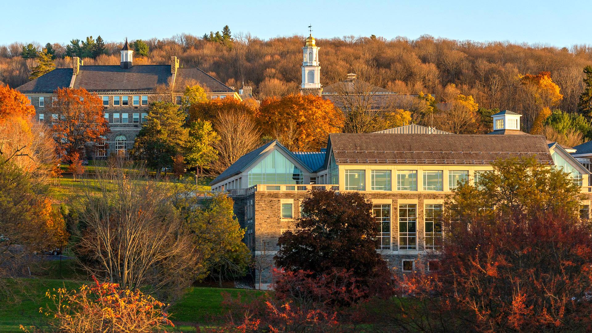 Fall foliage and sunlight falling on the library and Memorial Chapel