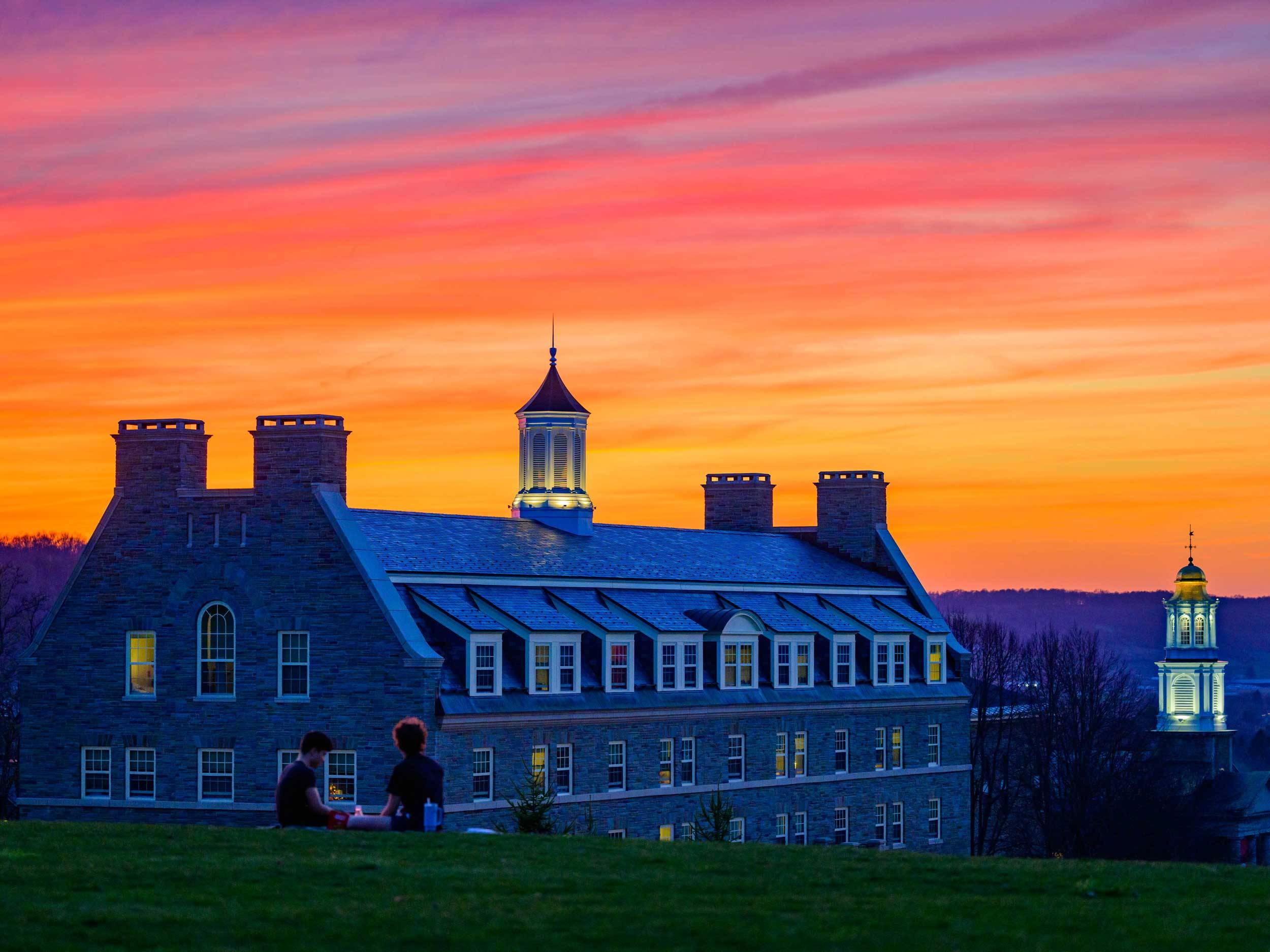 The sun sets over the Colgate campus with Jane Pinchin Hall and the Memorial Chapel in view