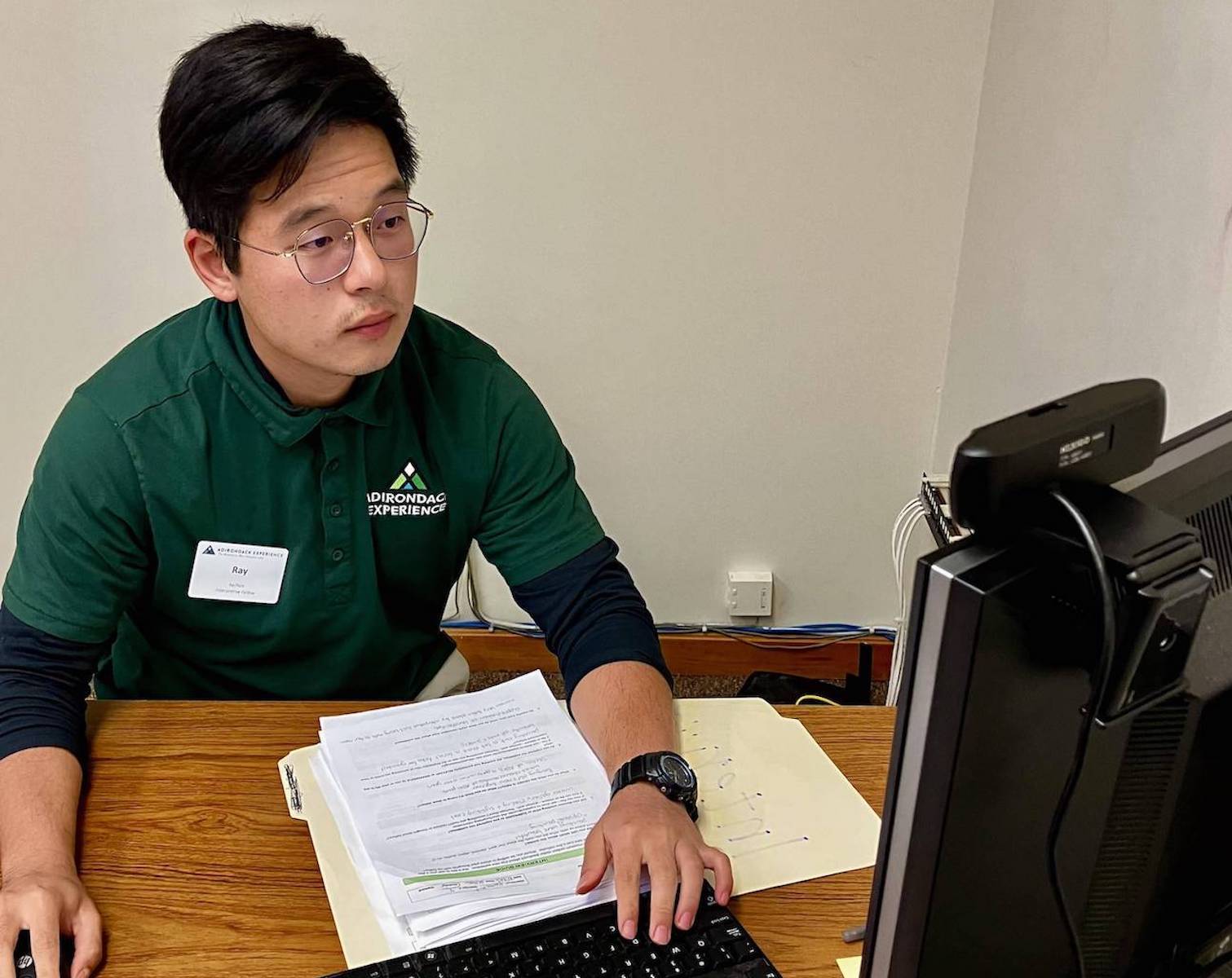 Zhang works at a computer at the Adirondack Experience.