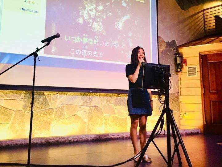Annie Wang speaks into a mic on stage