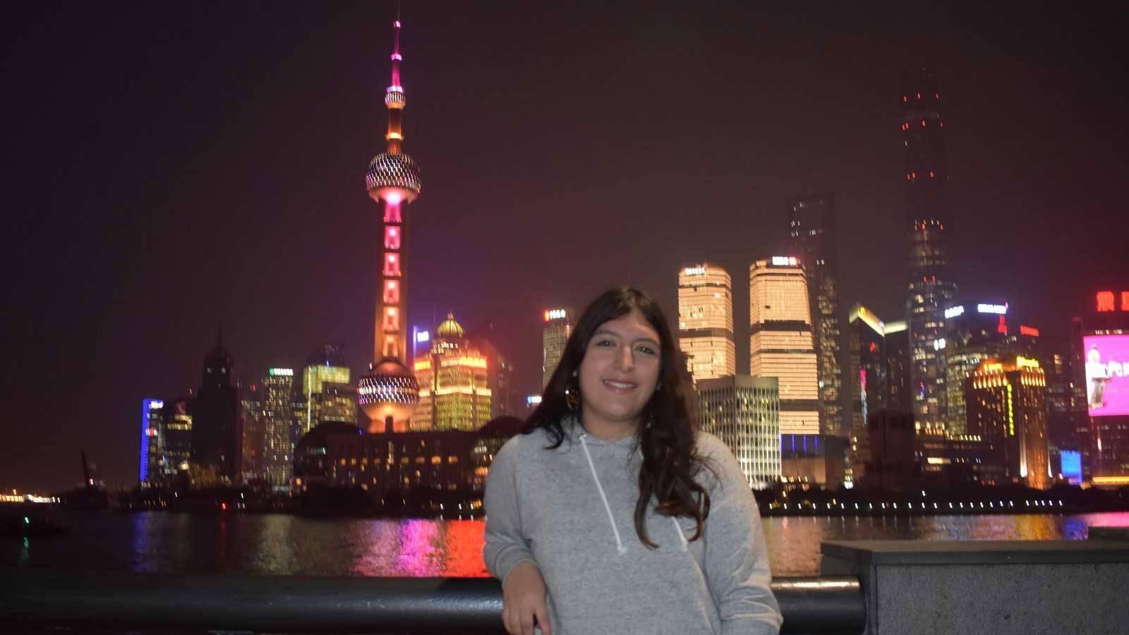 Elizabeth Gonzales in front of the illuminated Singapore skyline at night