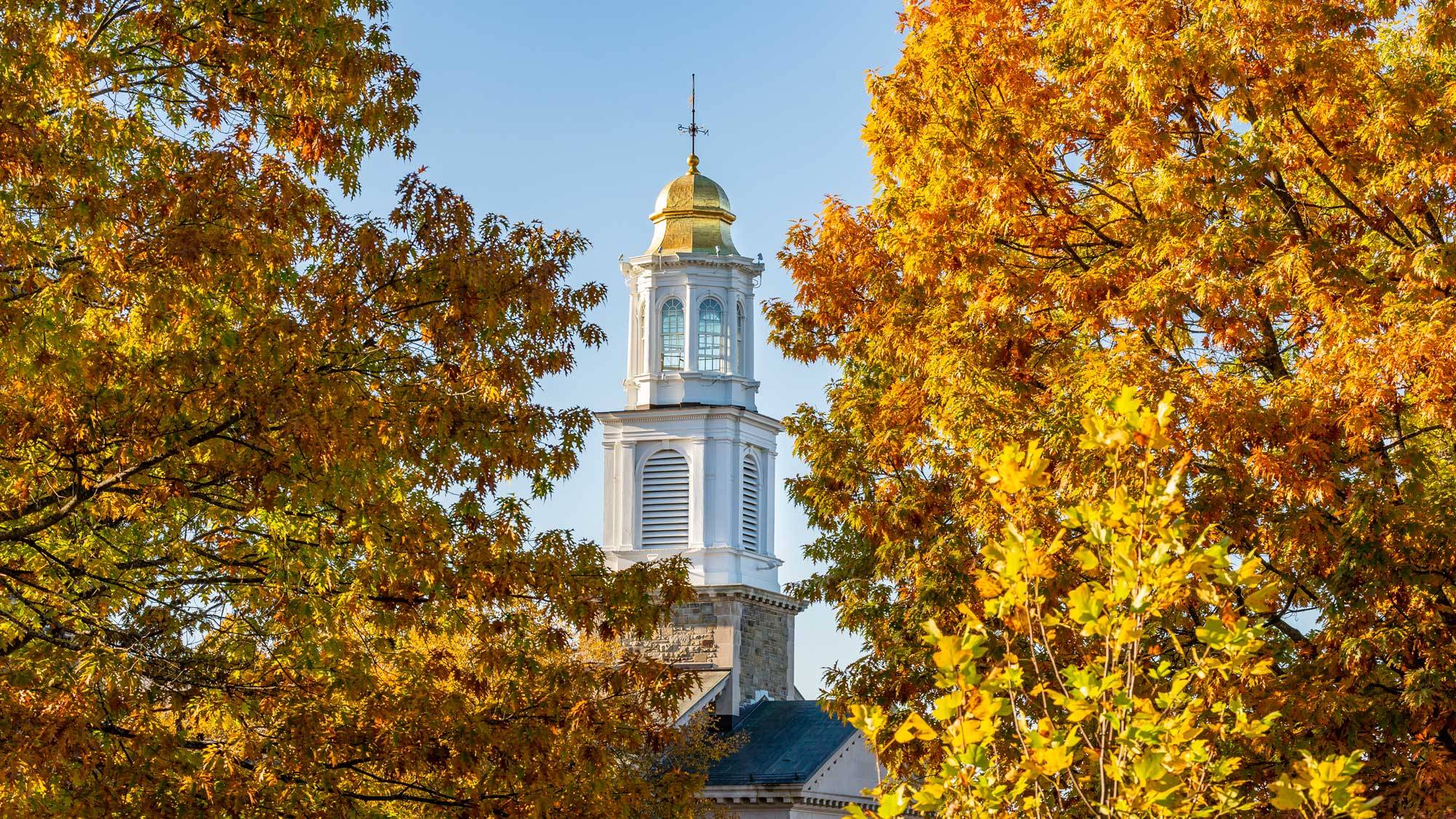 Chapel spire amid autumn foliage 