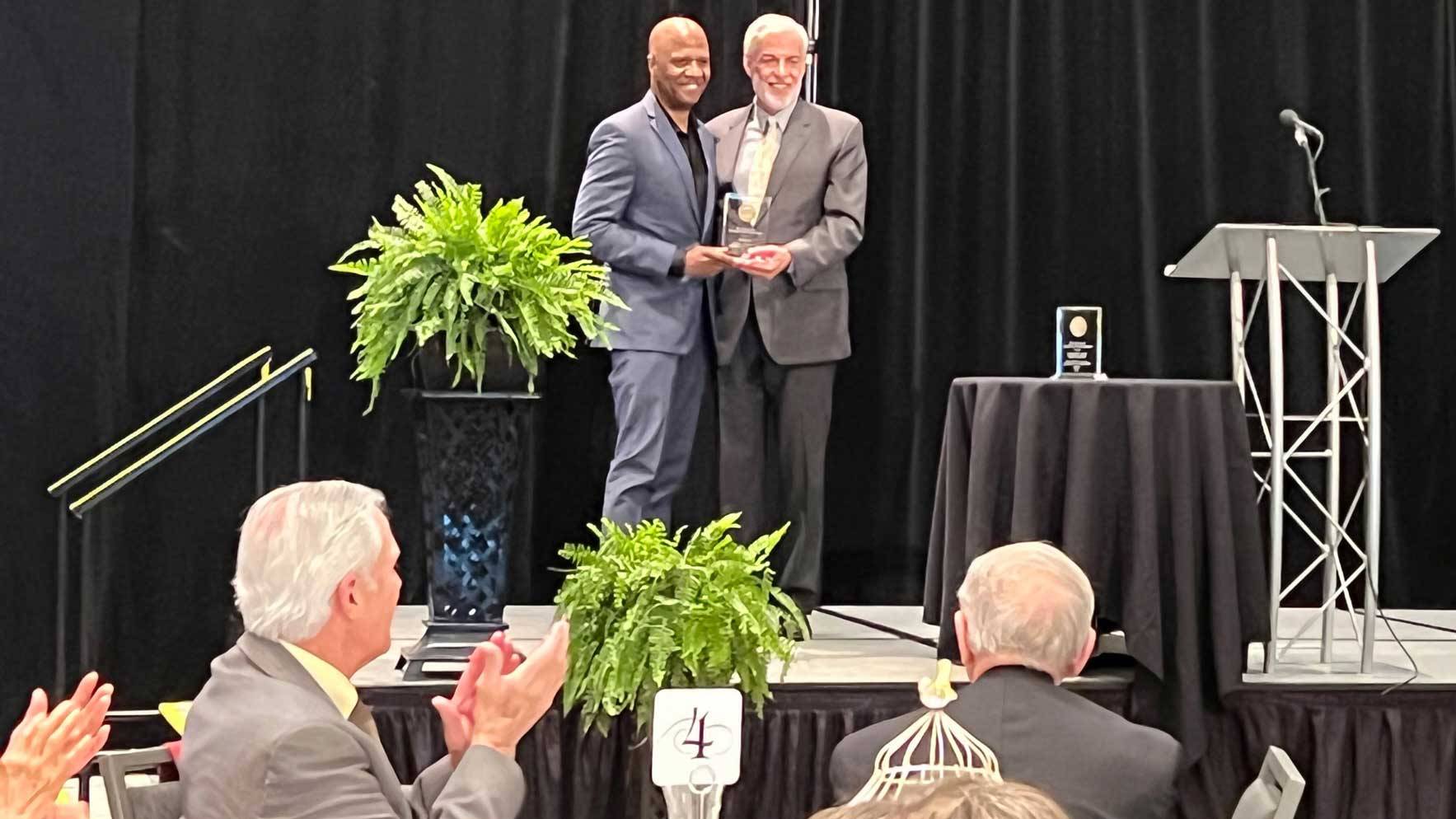 Prof. Kyle Bass receives award from OHA Executive Director Gregg Tripoli