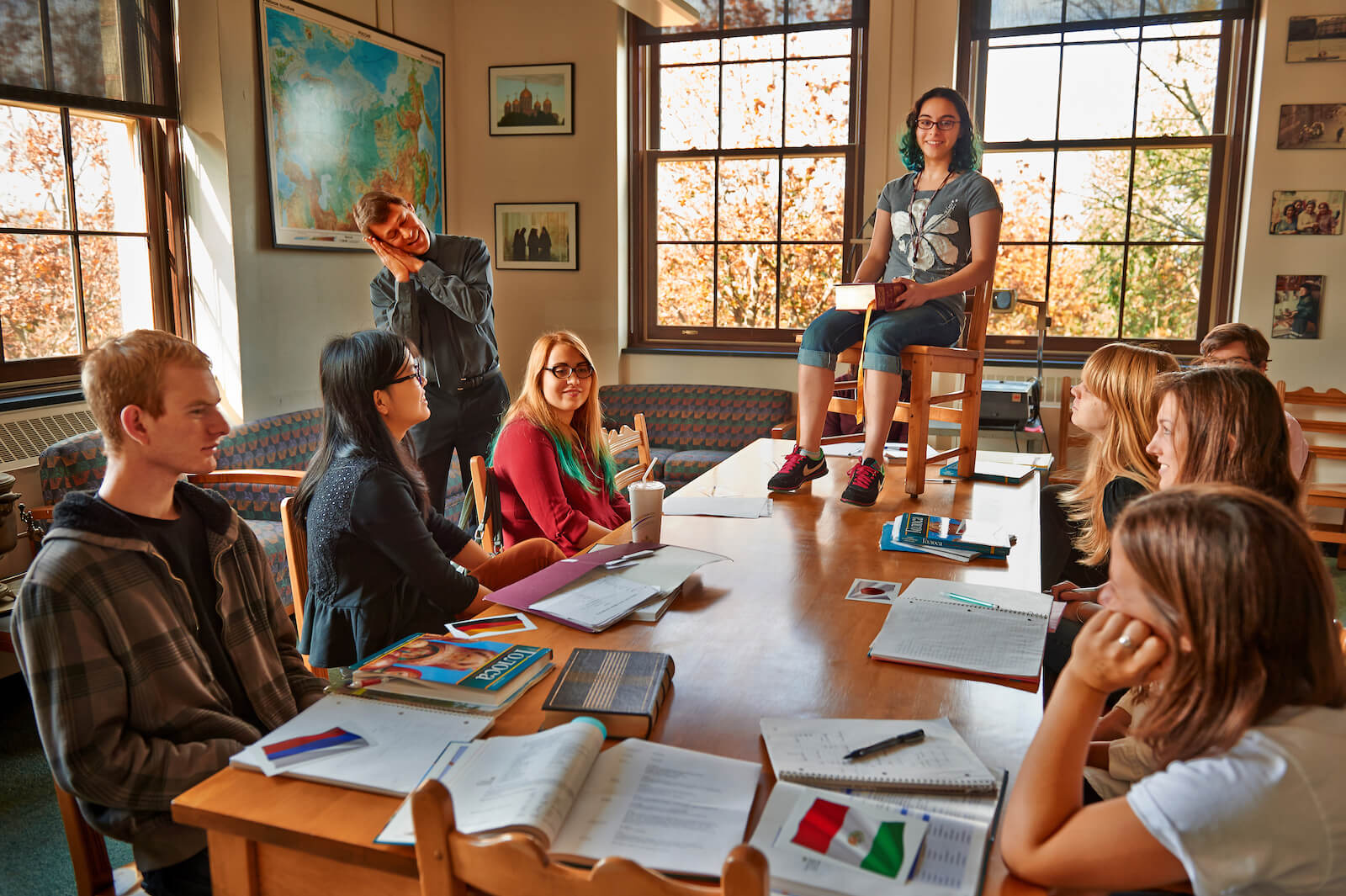 Student sitting on a chair on top a table during a lesson on prepositions.