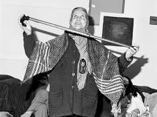 Black and white photo of woman dancing with a cane