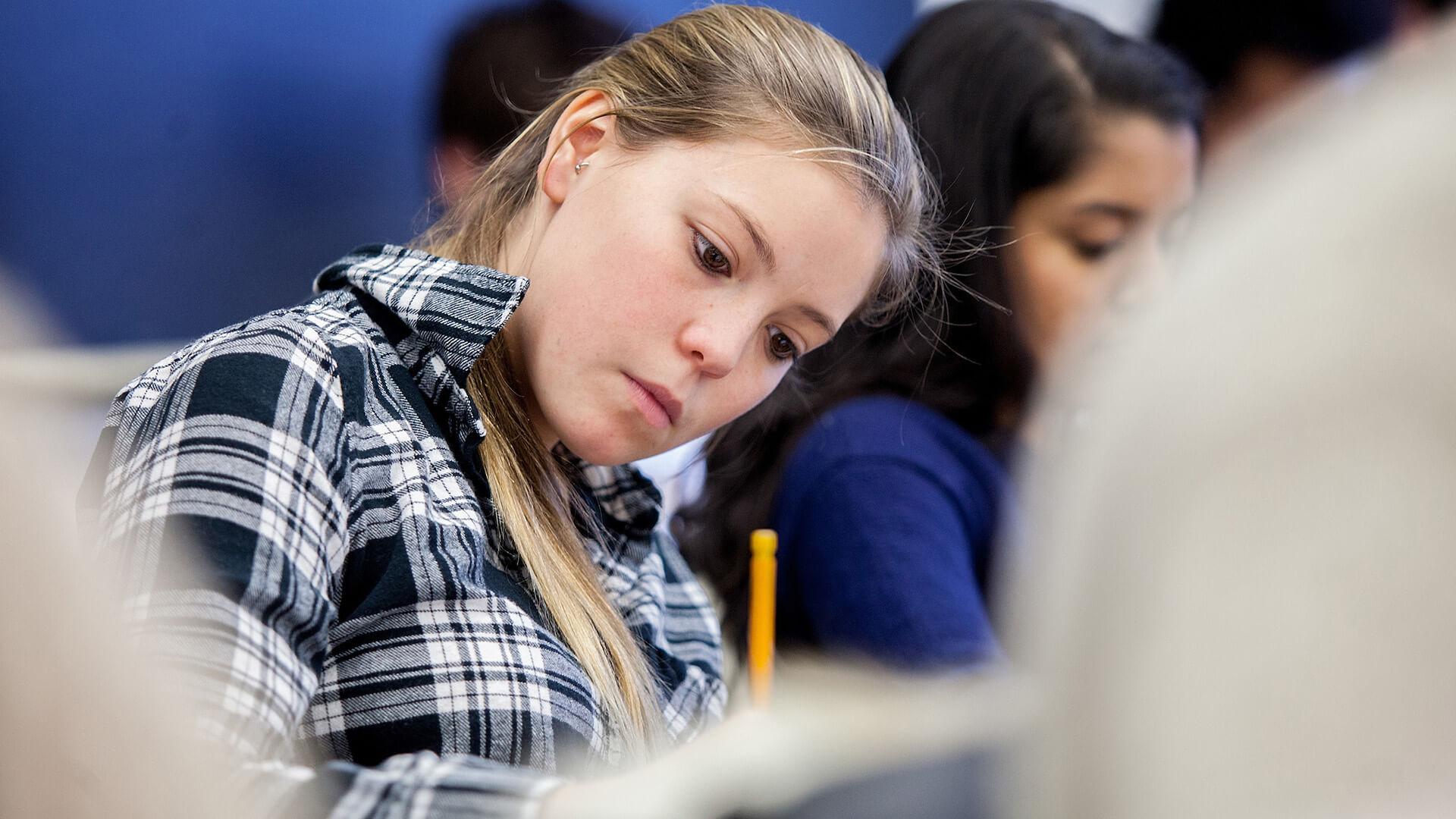 A Colgate student takes notes during a statistics class in McGregory Hall 