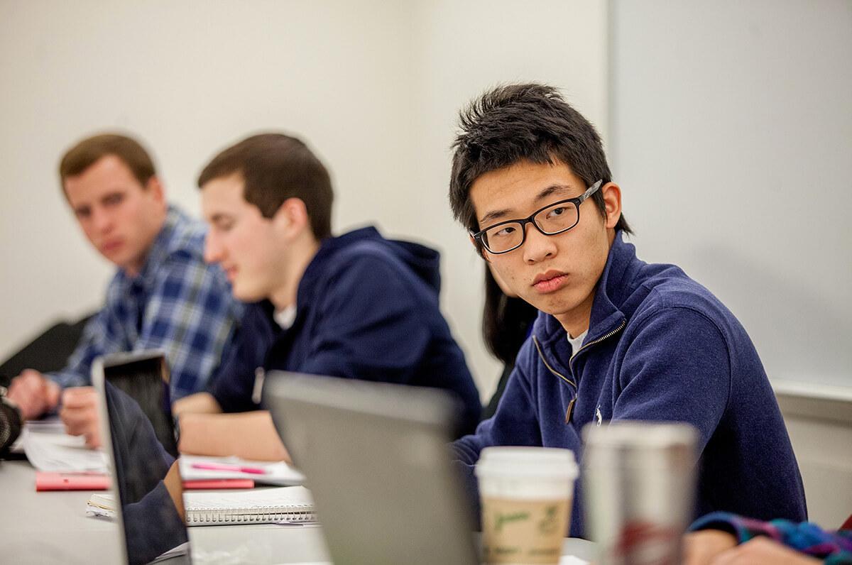 Colgate students listen in on a group discussion during a class on international finance and macroeconomics.