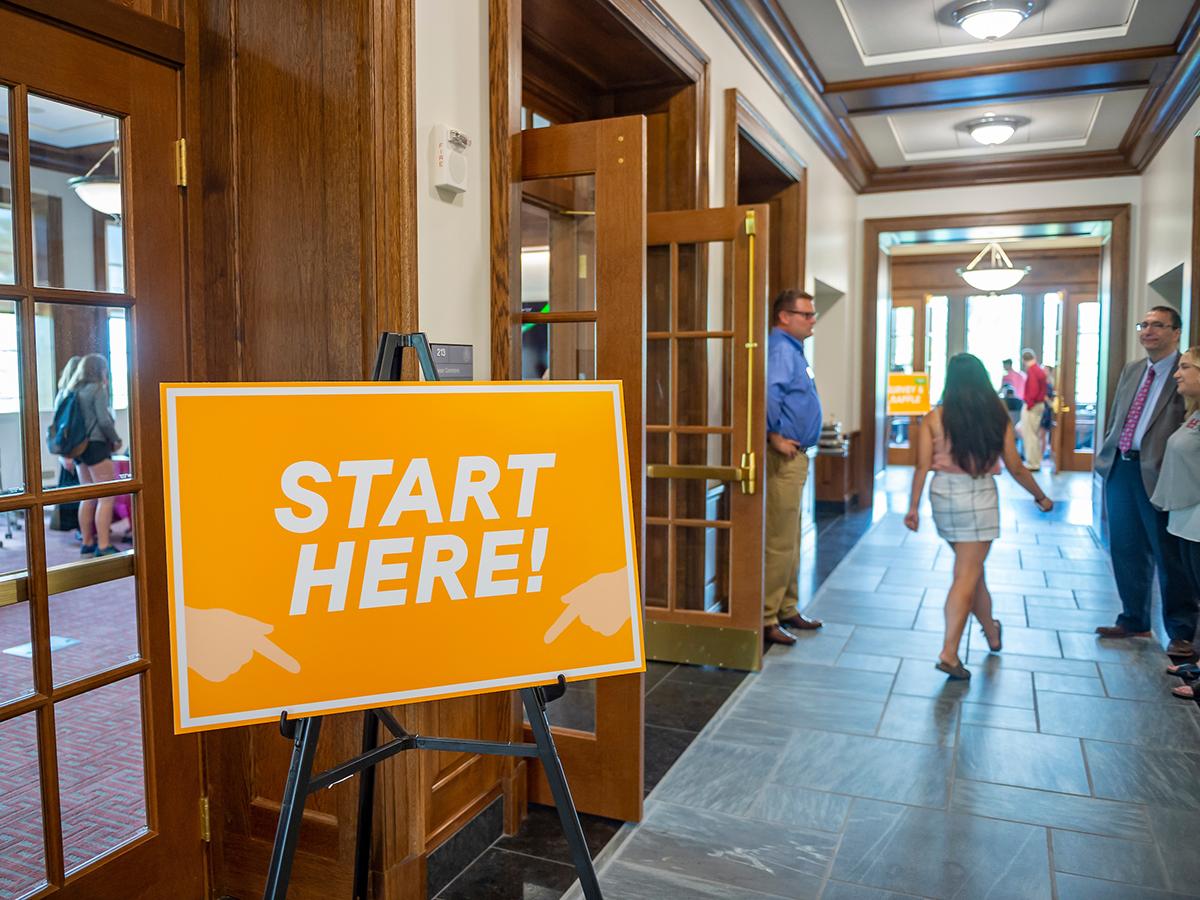 A sign in Benton Hall that reads “Start Here”
