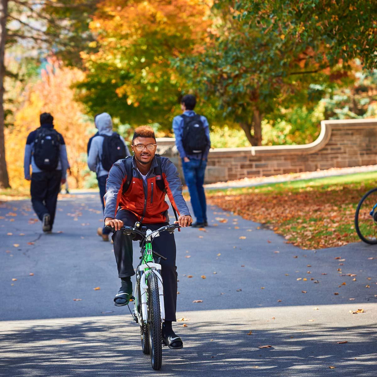 A student rides his bike on the academic quad between classes.