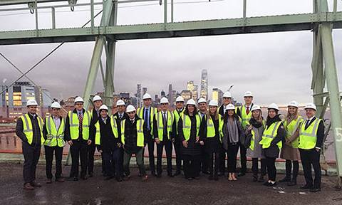 Students dressed in safety vests and hard hats at a construction site visit