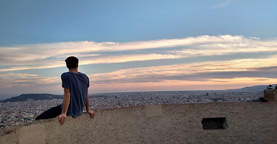 Student sitting on ledge overlooking the city of Barcelona
