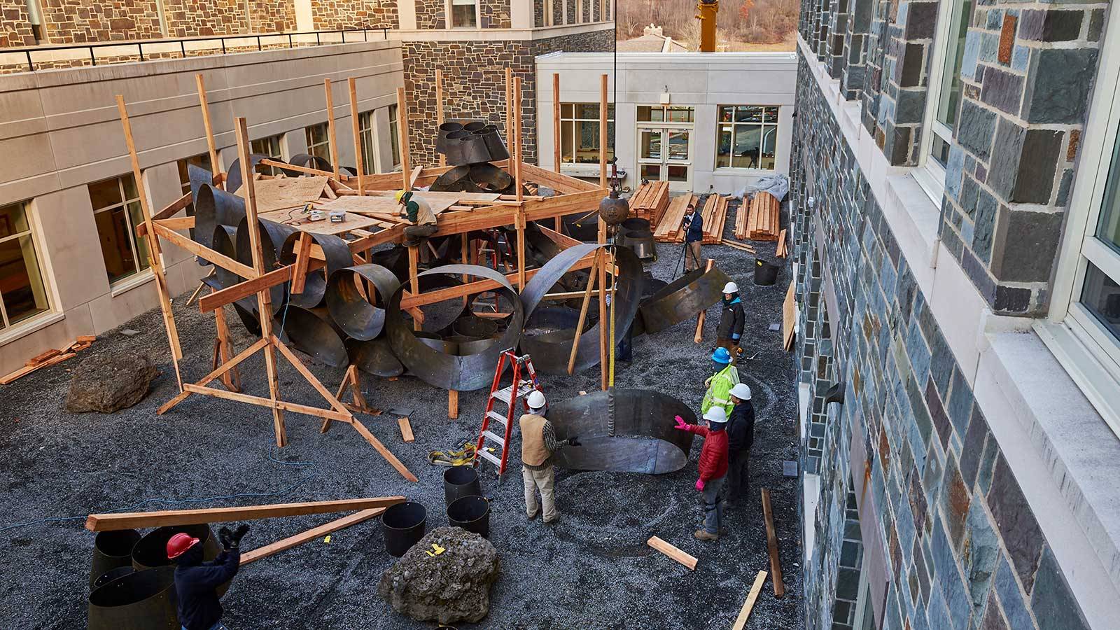 Workers use scaffolding to assemble the sculpture Odin, which was created as an interdisciplinary collaborate between faculty members from the arts and from mathematics