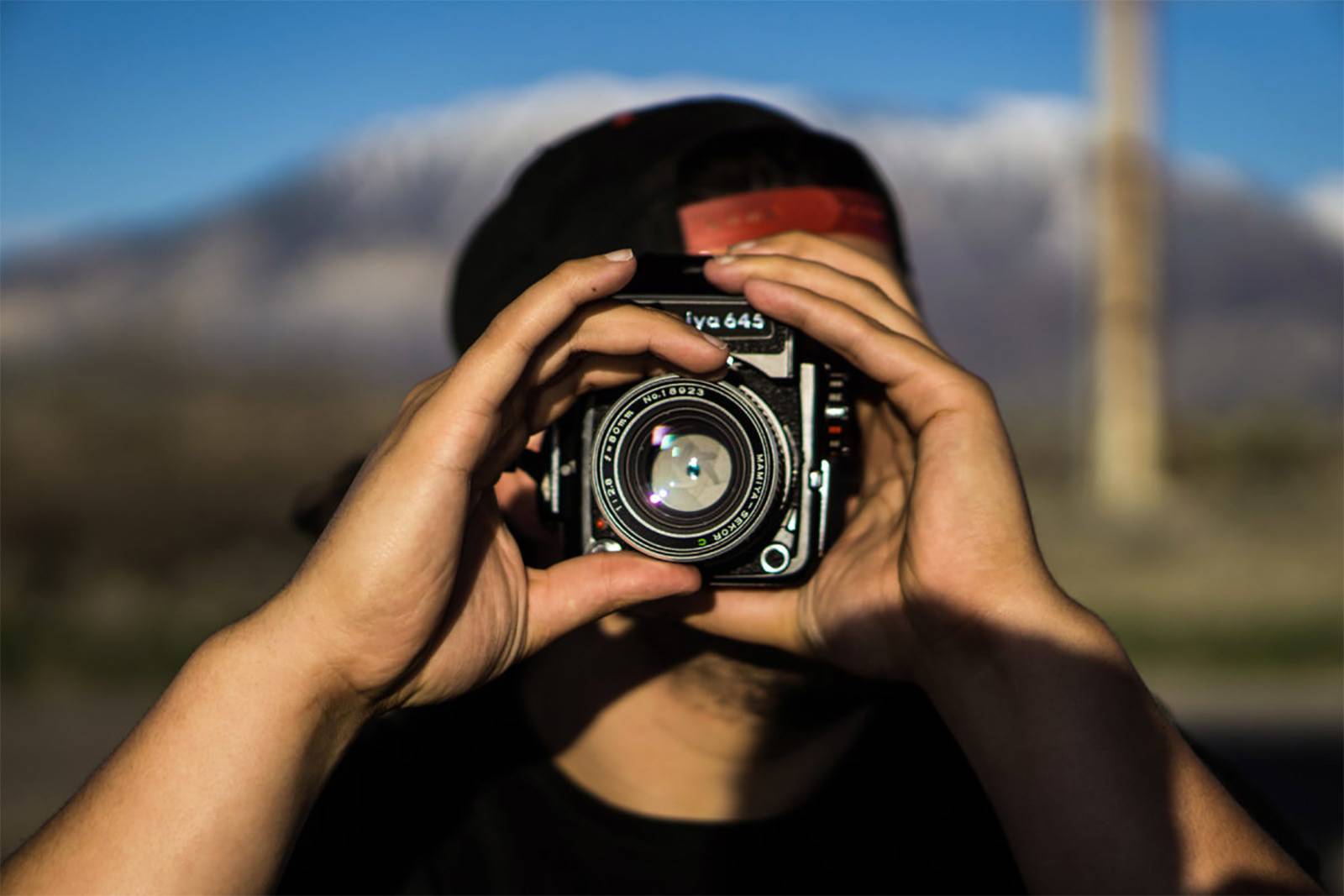 A man looks through a camera.