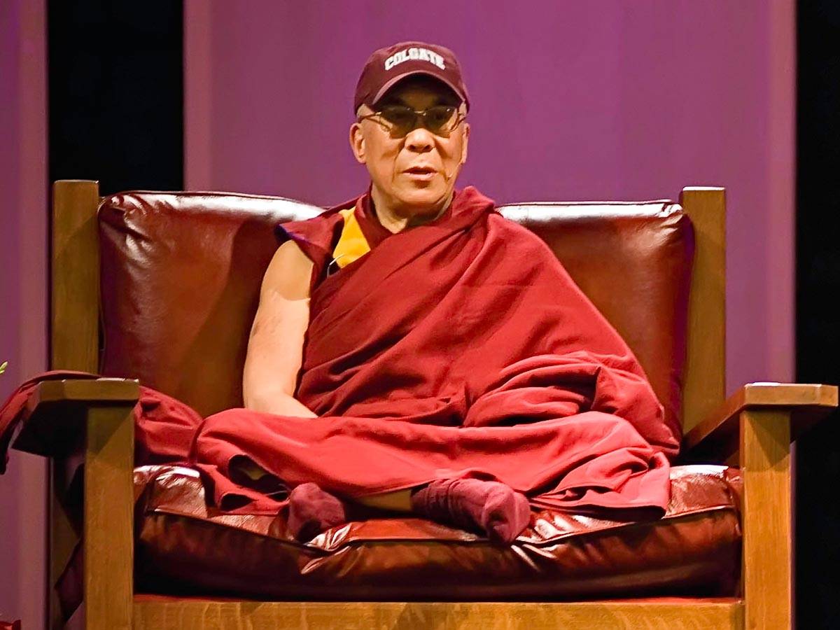 The Dalai Lama wears a Colgate hat while speaking in Sanford Field House