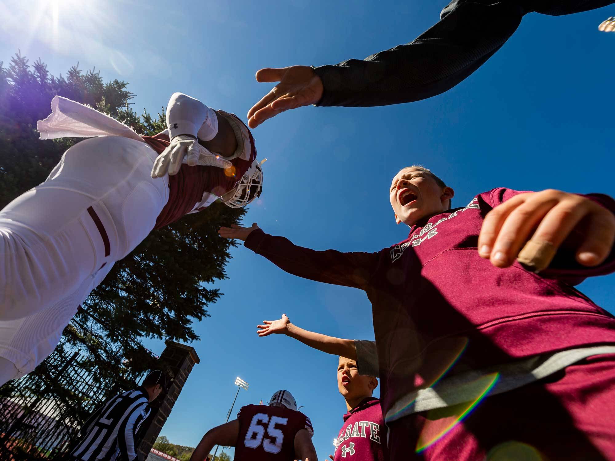 fans give high-fives to football players