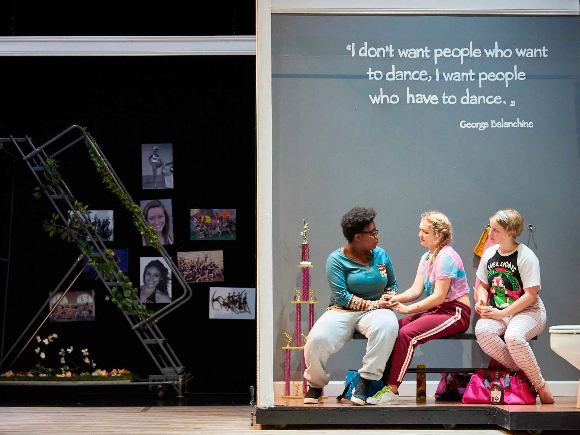 Three actors on a bench, talking, Balanchine quote about dance on board behind them