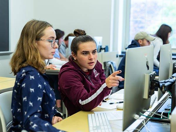 Students at a computer workstation in a classroom