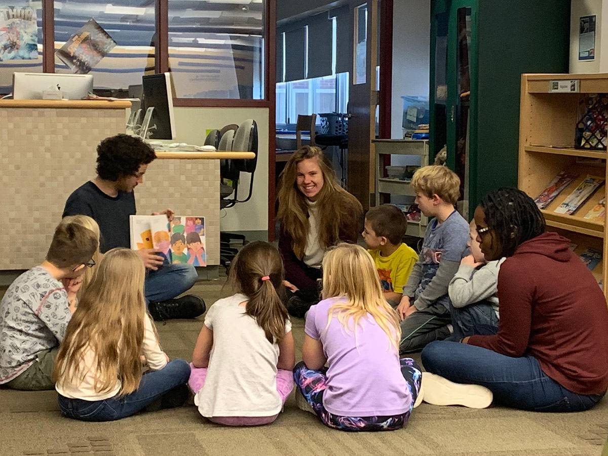 Colgate students reading to young children at a school
