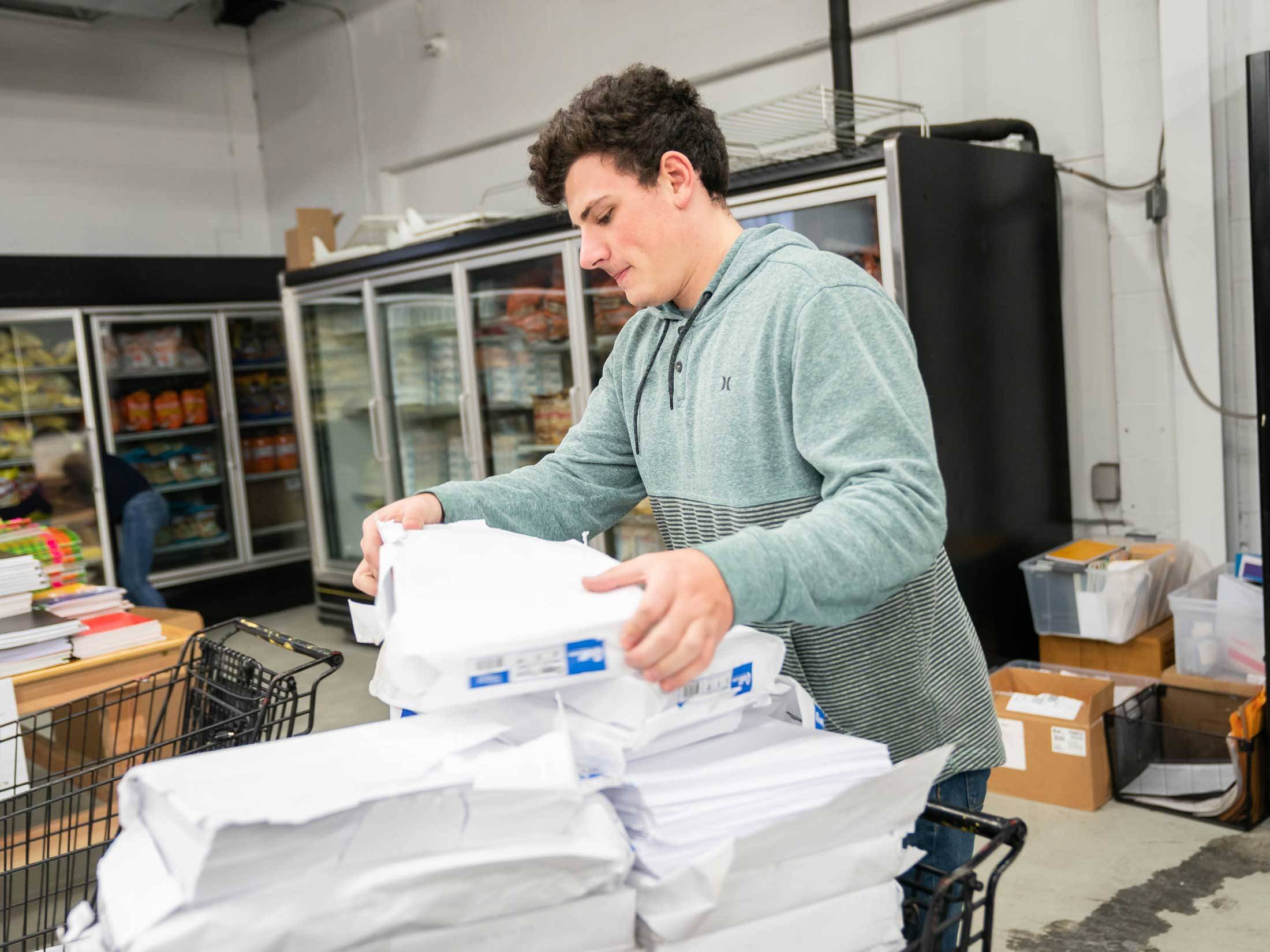 Student stacks paper in storage room