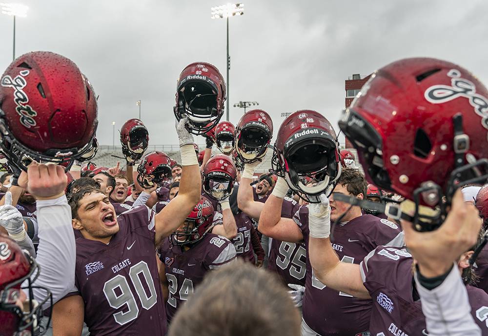 Football team chants and raises their helmets