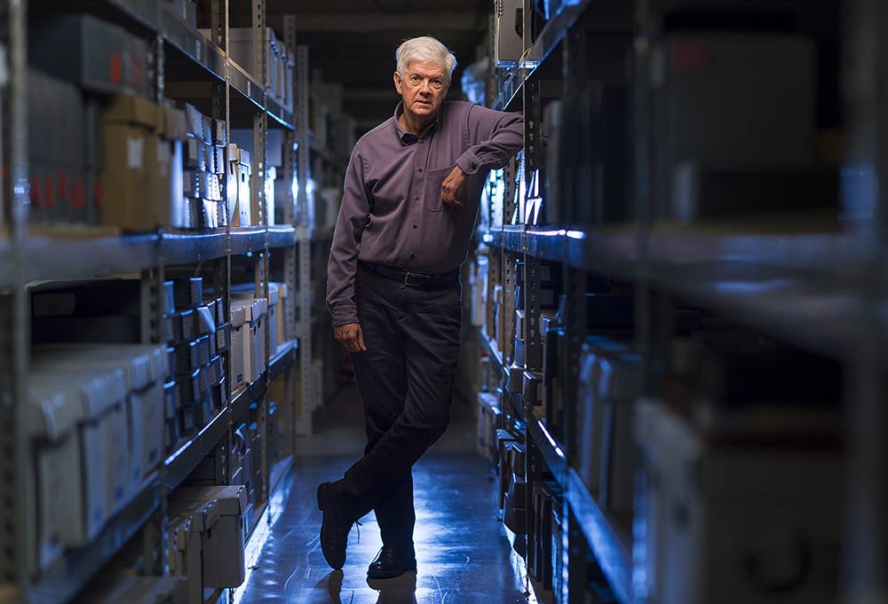 Jim Smith ’70 leans against a shelf in the Colgate archives