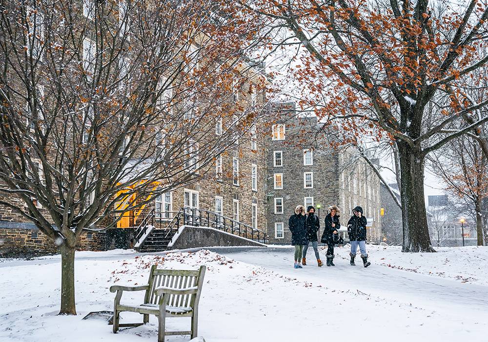 Four Colgate women walk together across the residential quad