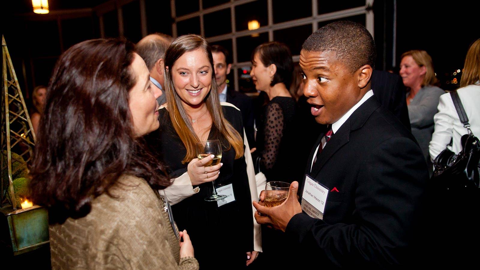 Alumni converse over drinks at an off-campus Colgate event