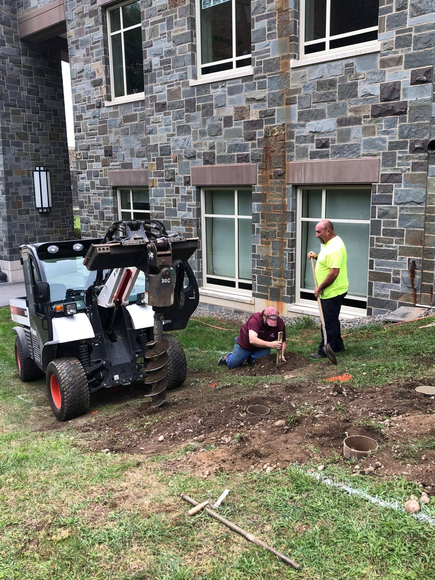 B&G employees work on installing the petrified wood specimens