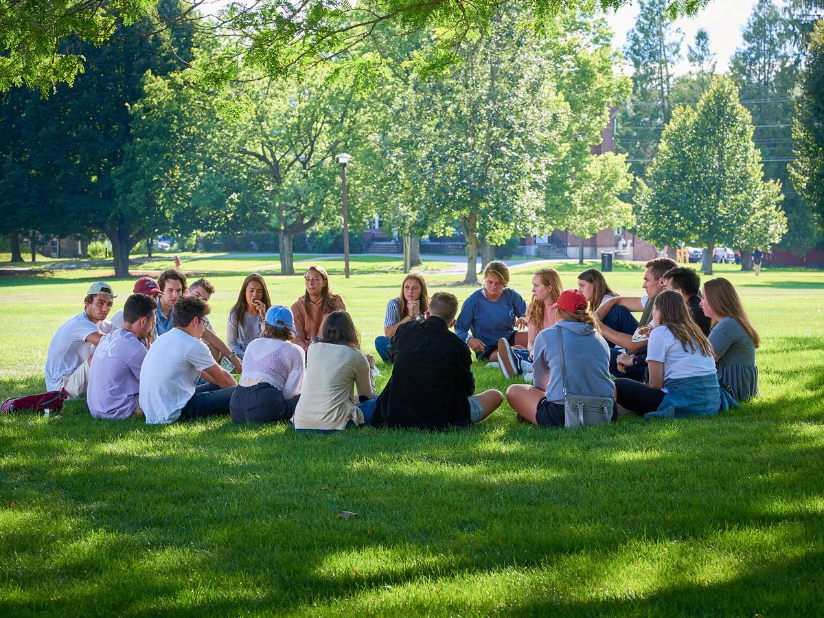 Students sitting in a circle outside during Orientation.