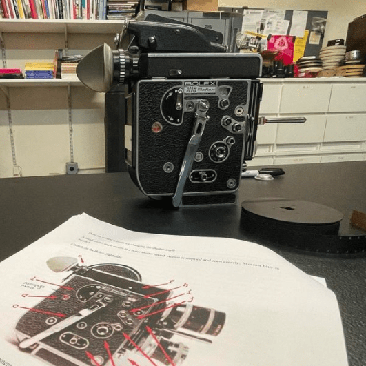 16mm Bolex camera on a table with a diagram and notes.