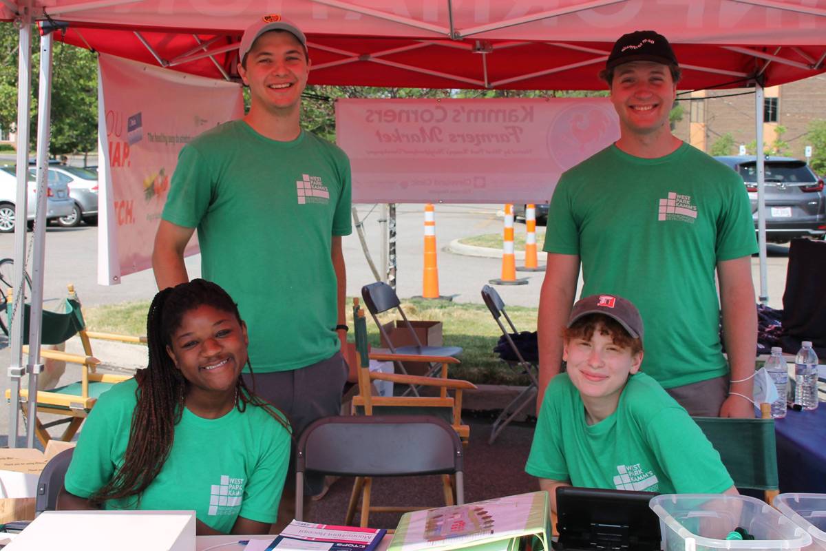 Trinity West and a group of student interns under a tent.