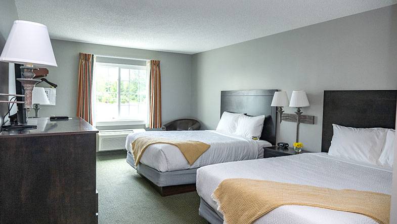 Hotel room with two beds and a dresser