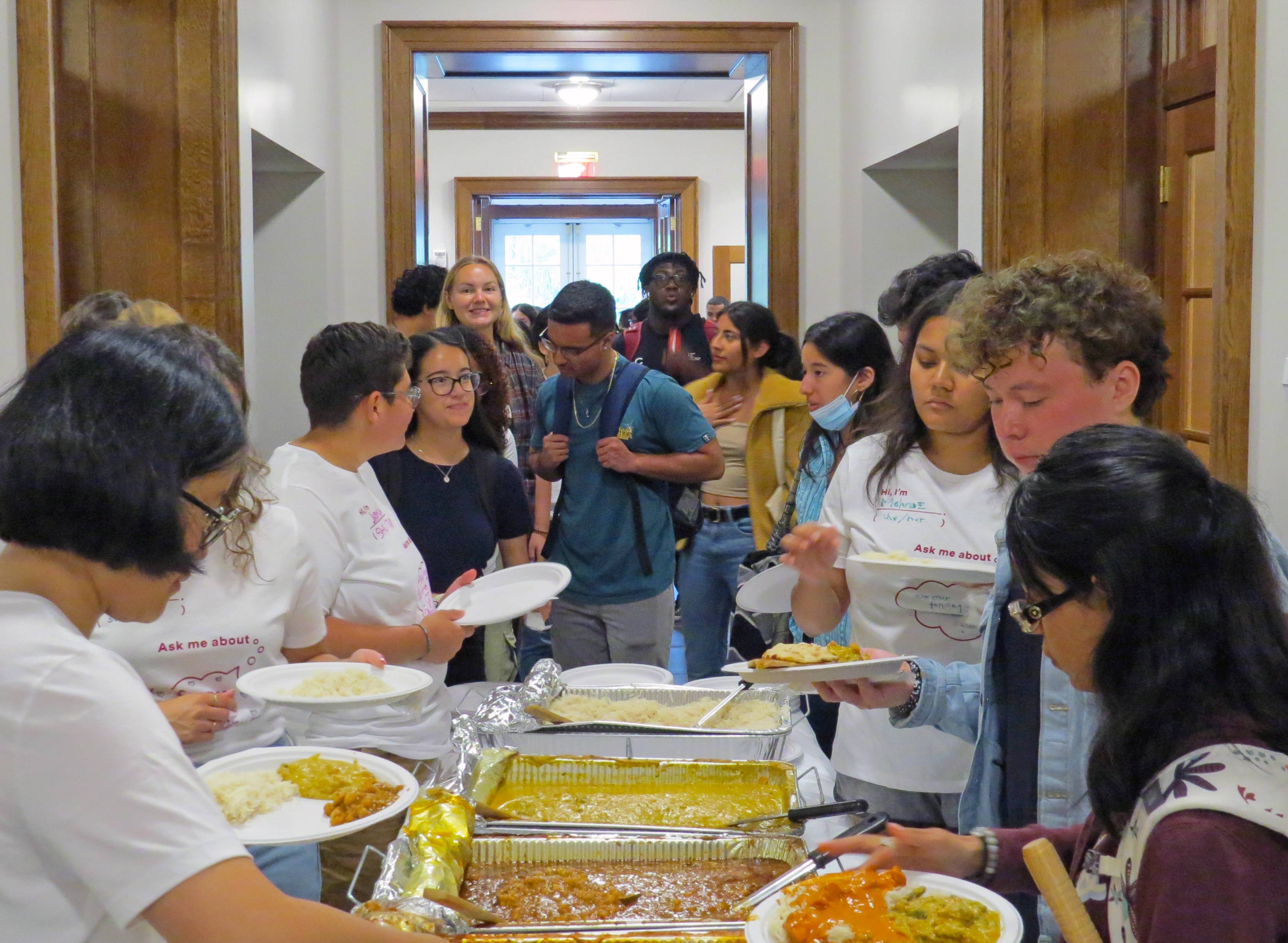 Students gather around table of food from RIG