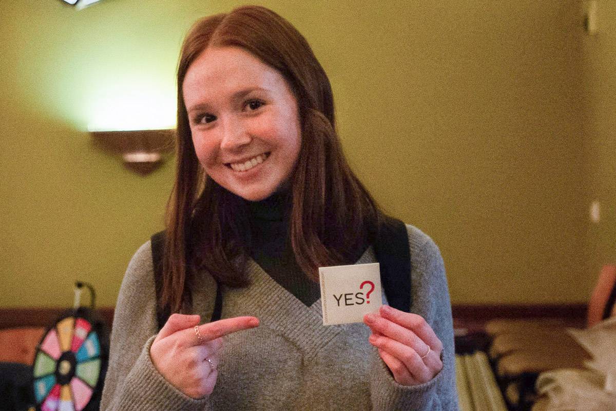 Student at the sex museum holding a yes sticker