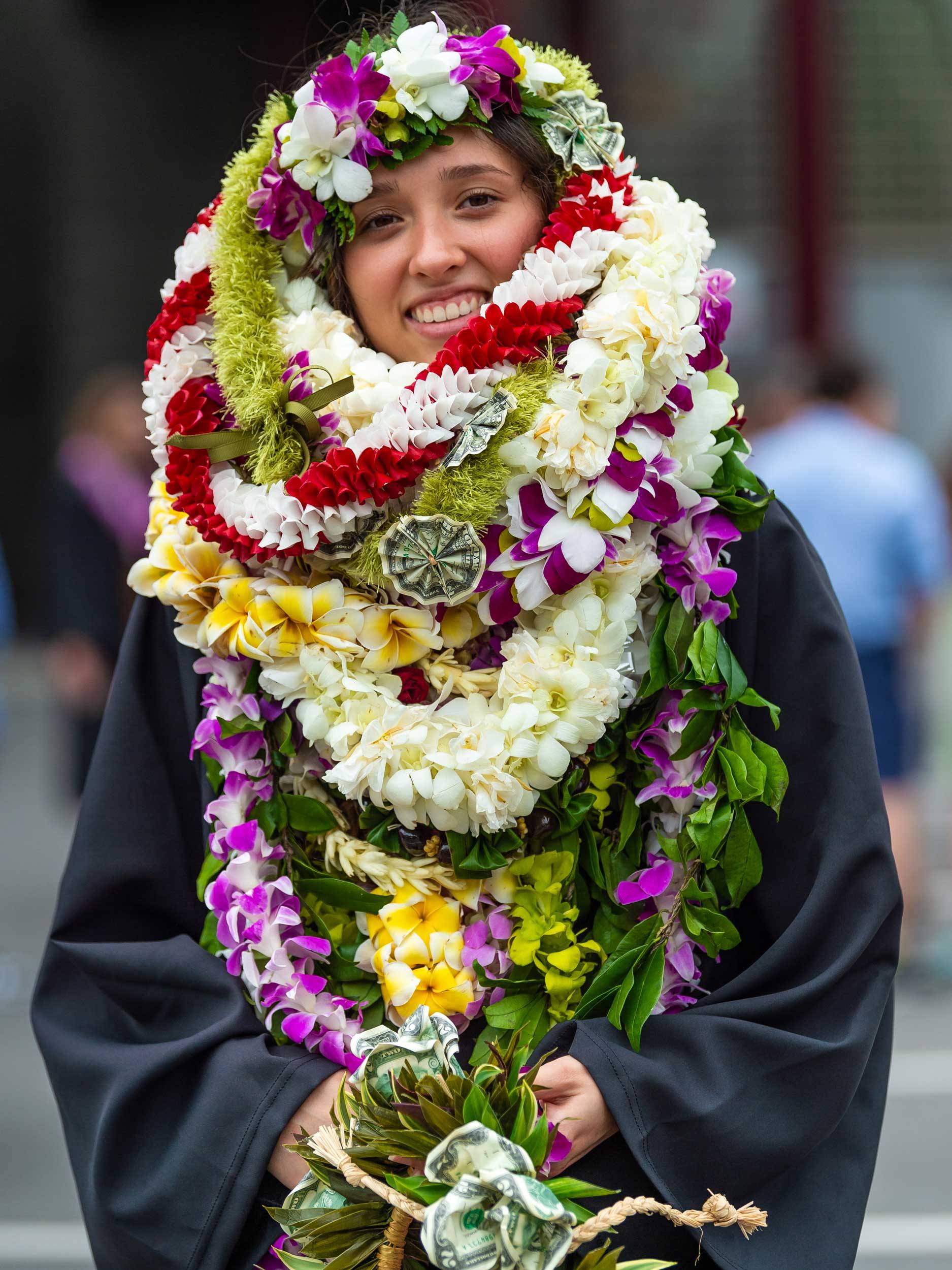 Student wrapped in flowers at commencement