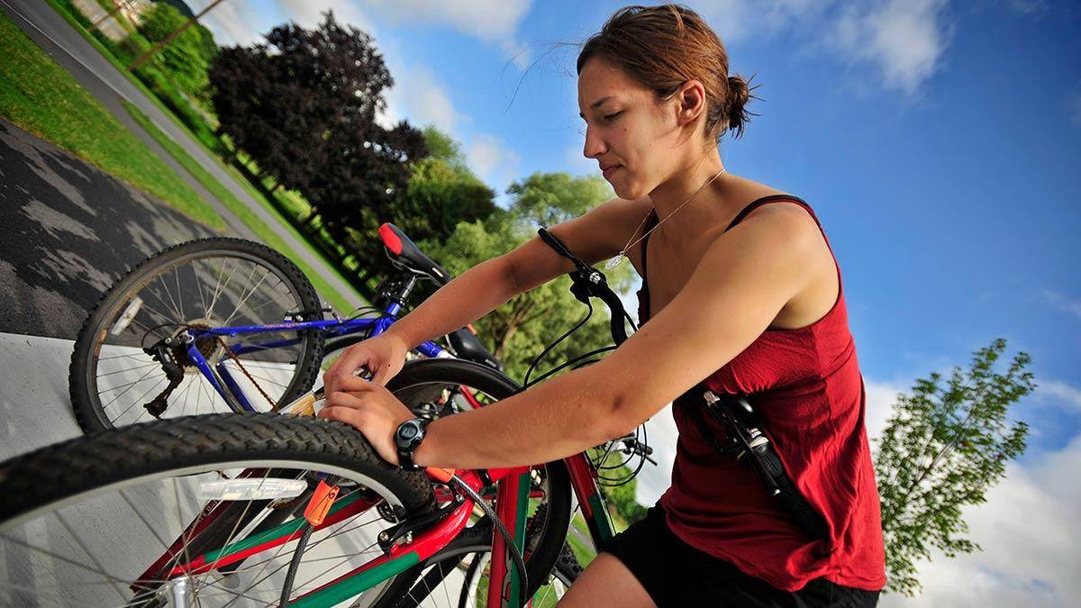 Student locking a bike to a bike rack.