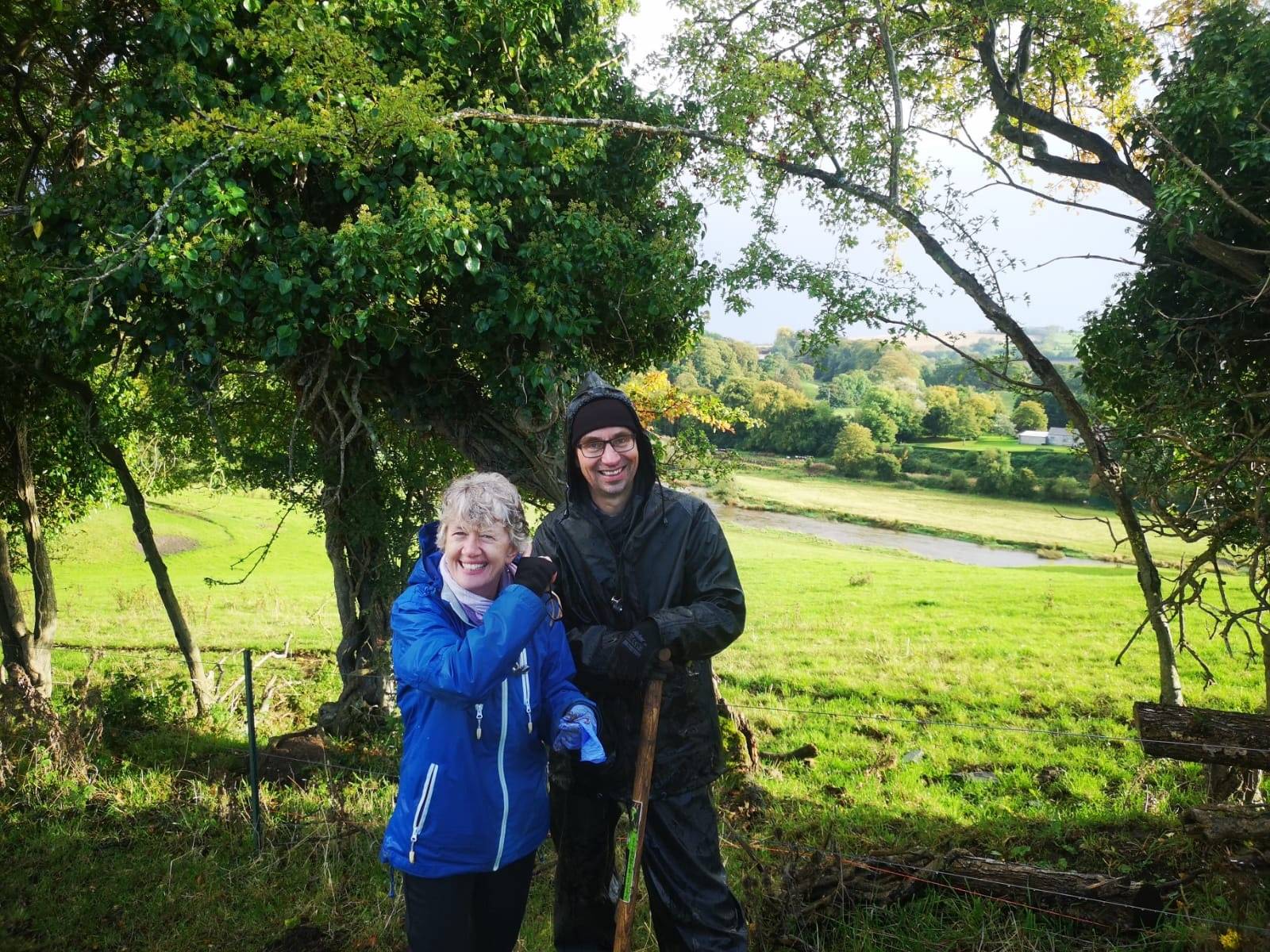 man and woman stand outside under trees