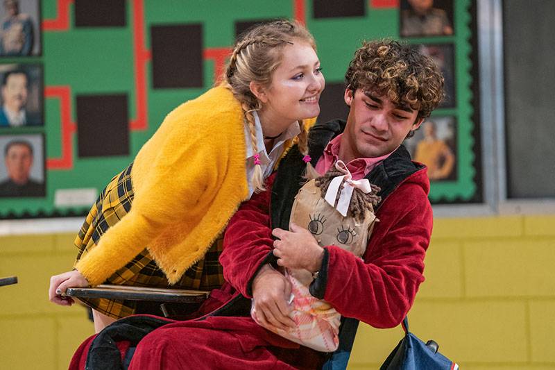 TWo student actors on stage during the Juniors production