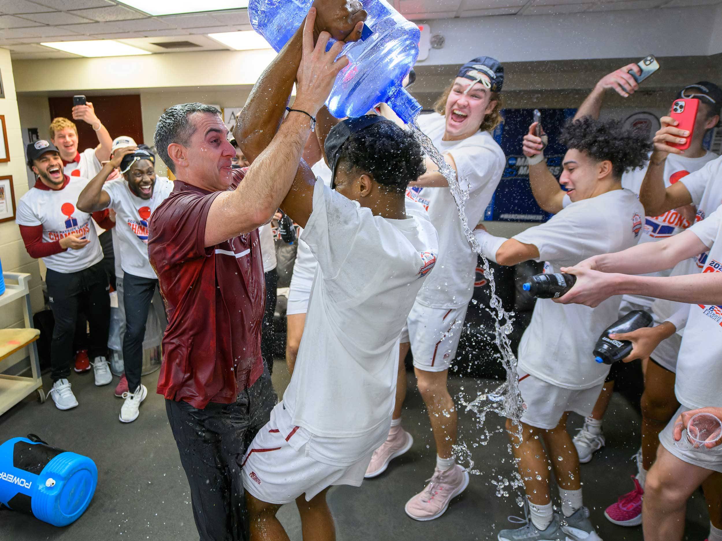 Colgate Men’s Basketball Coach Matt Langel and Colgate guard Nicolas Louis-Jacques struggle for control of the water jug