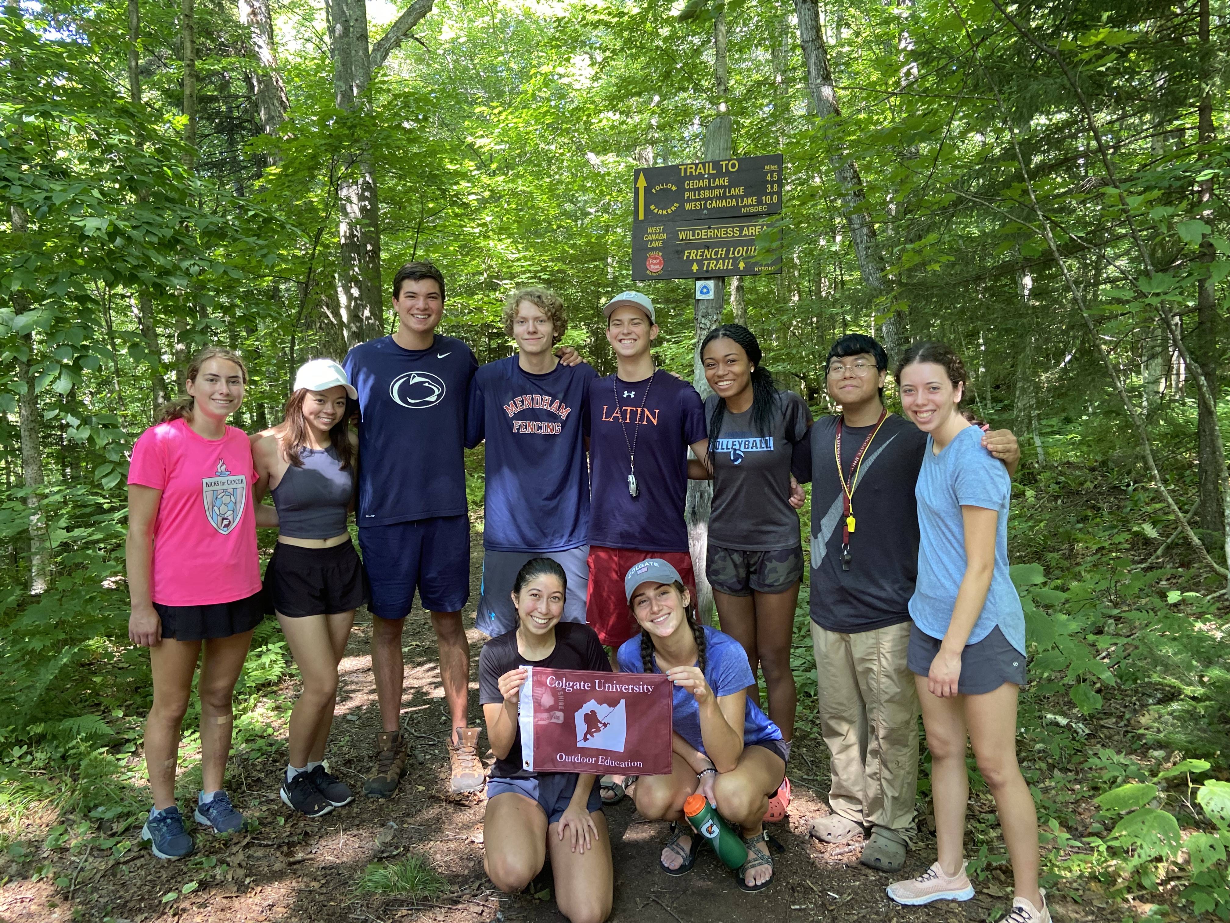 Students pose in the forest during a hike