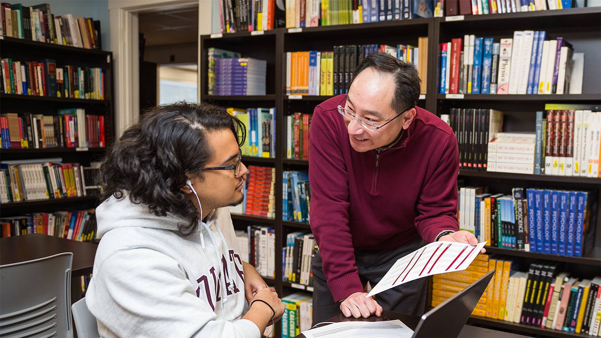 A staff members assists a student
