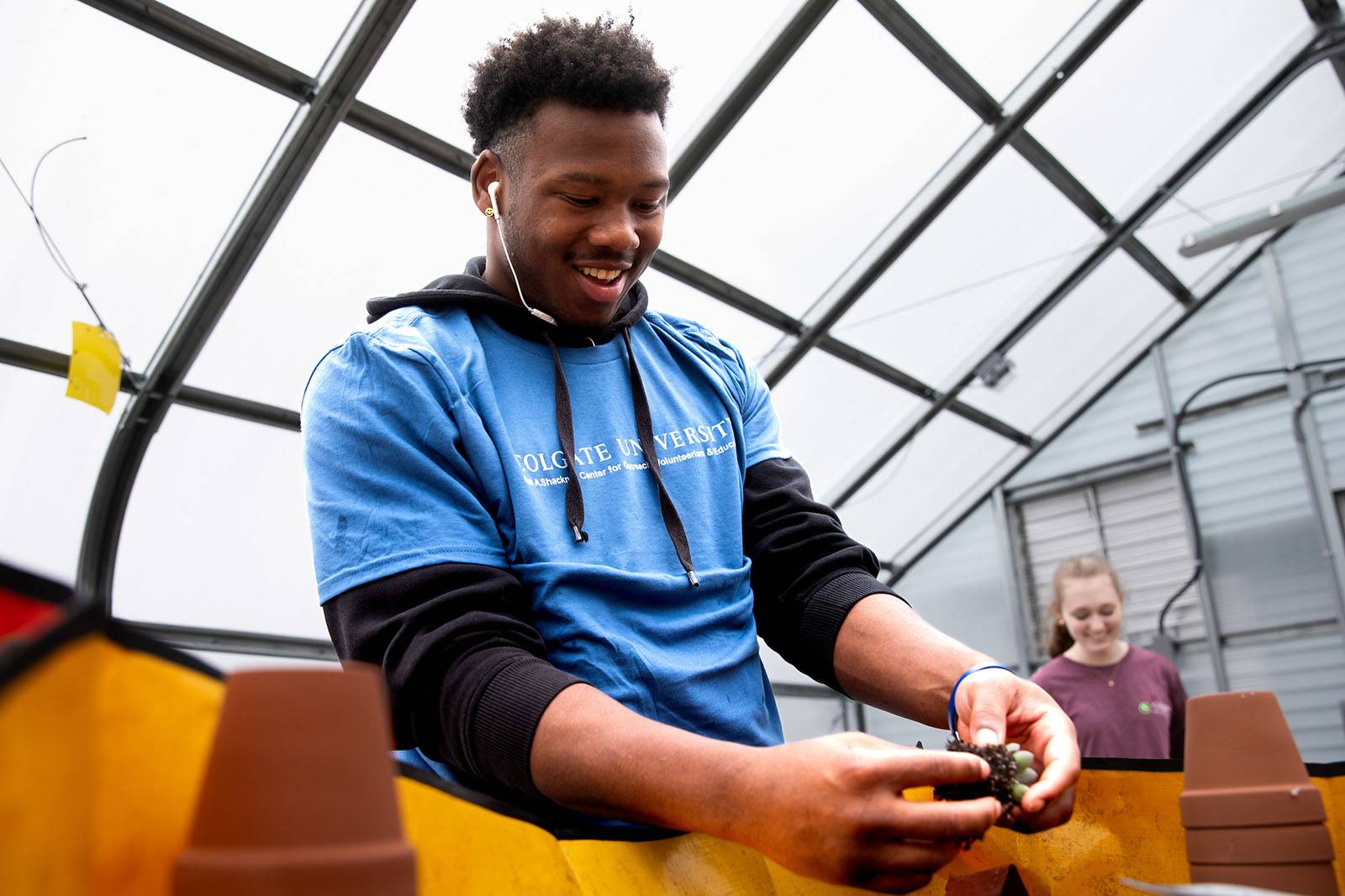 Two students volunteer in the greenhouse