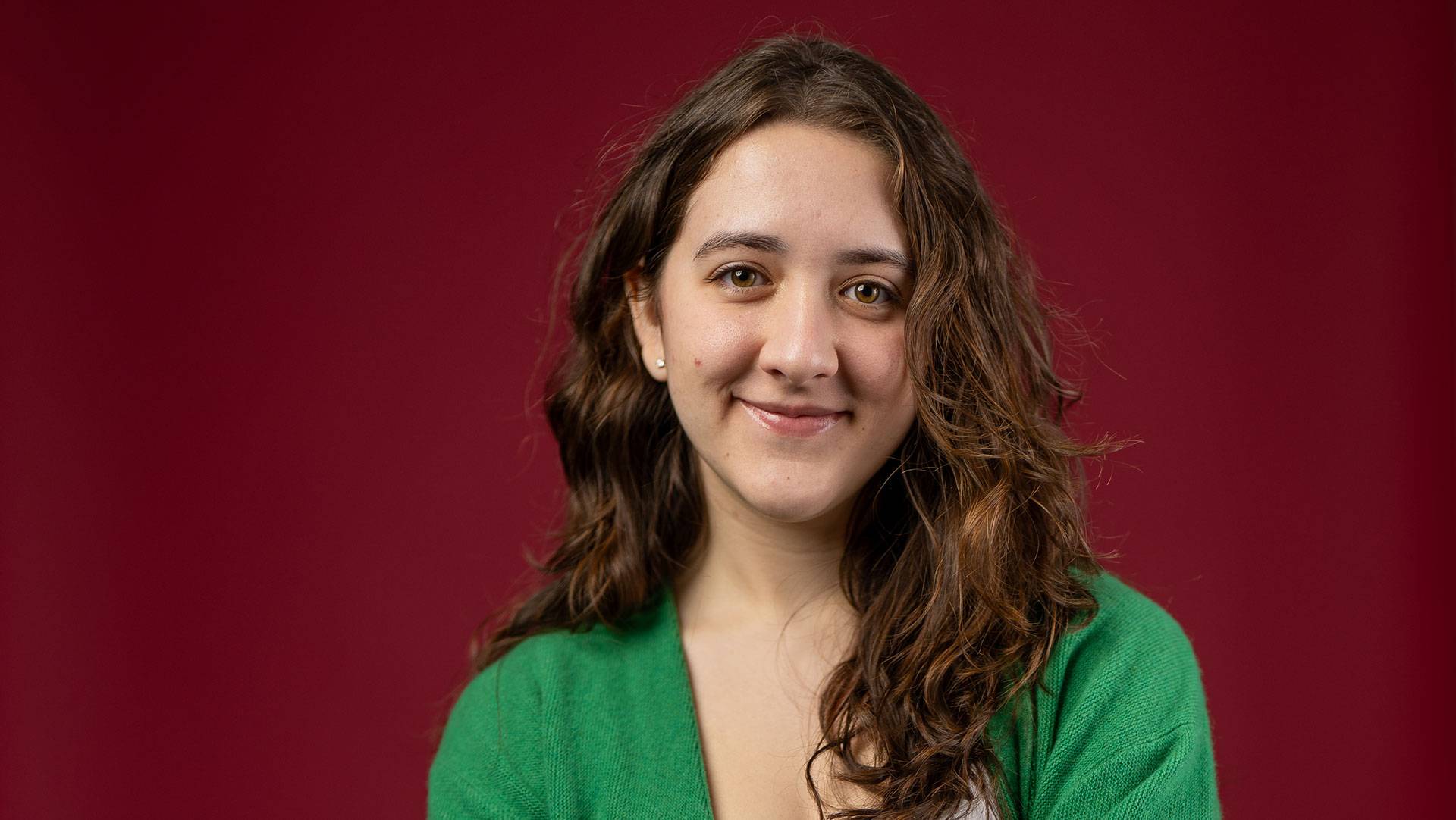 Farrell standing in front of a red background.