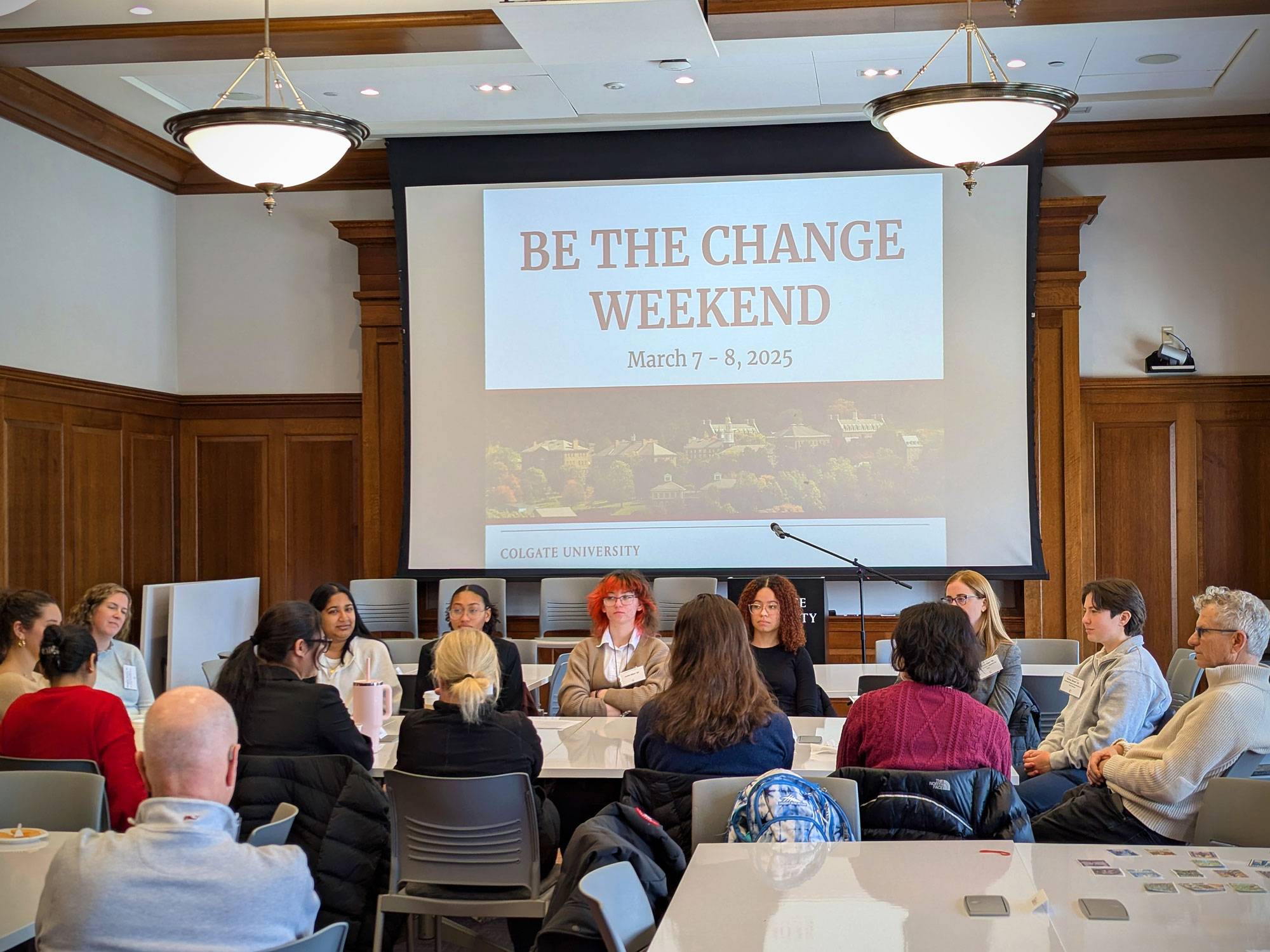 Students, alumni, and staff sit together at a table
