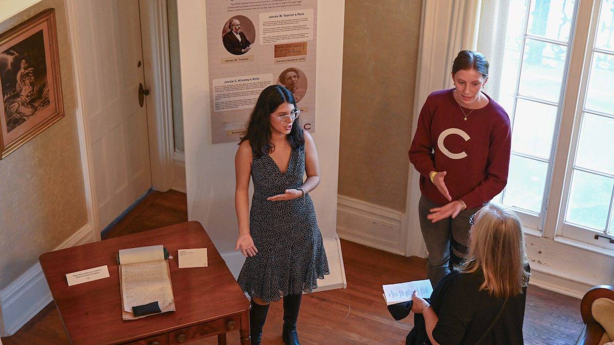 Alondra Bocerra ’24 and Abby Shadwick ‘25 discuss their exhibit “Charisma Vs. Contracts” during the opening of “Fresh Perspectives on the Oneida Community Mansion House” April 30.