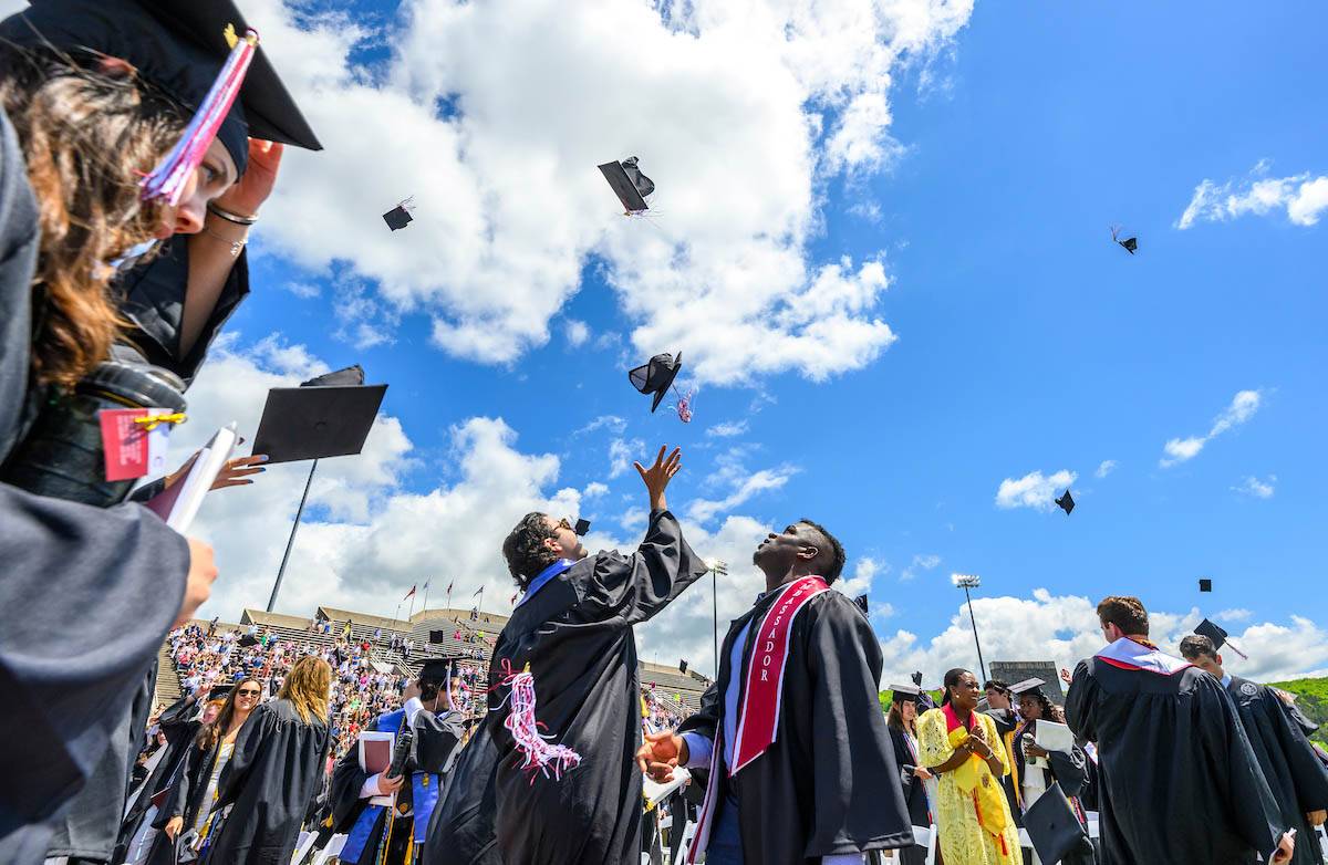 Graduating students throw caps in the air